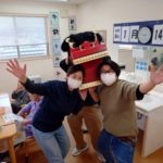 複数の入居者がクリスマスサンタの装飾品と共に室内でレクリエーション活動を楽しんでいる様子